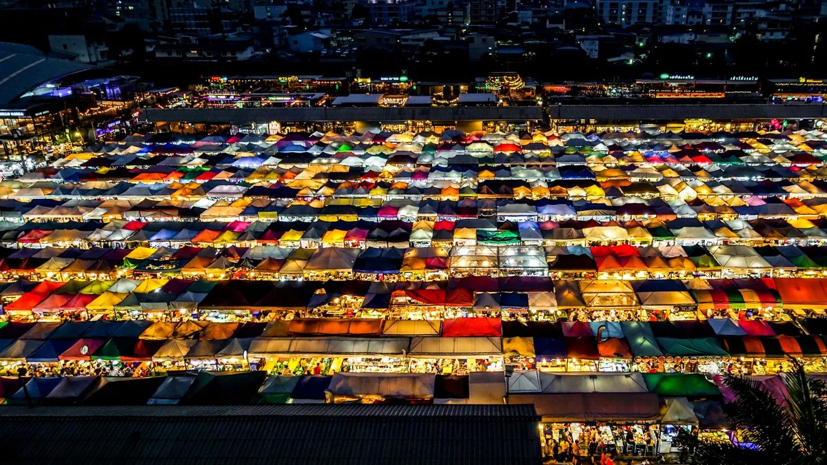 Illuminated colorful canopies over Bangkok night market stalls