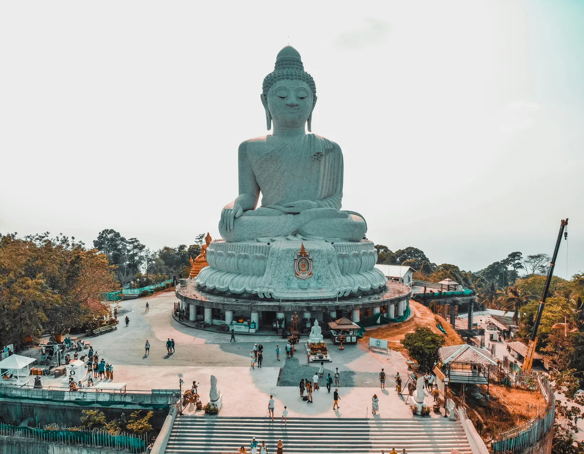 Big statue of Buddha surrounded by trees