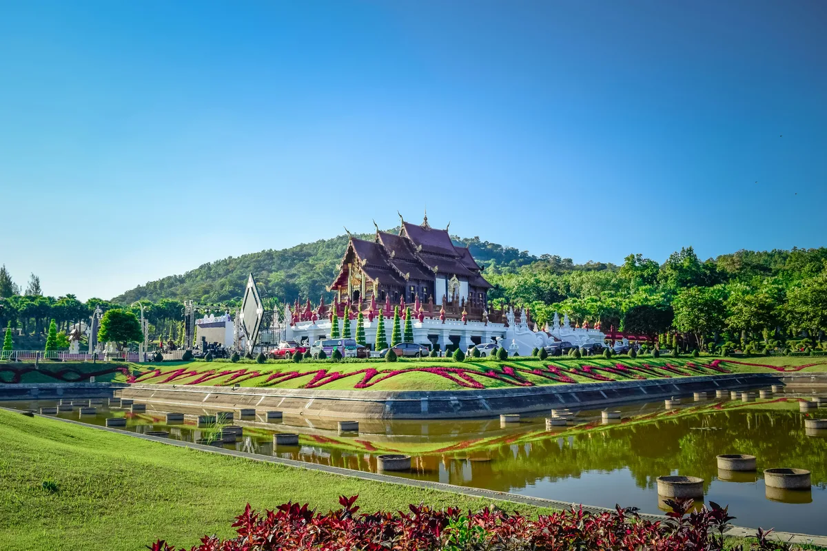 A big building with Thai surrounded by beautiful gardens