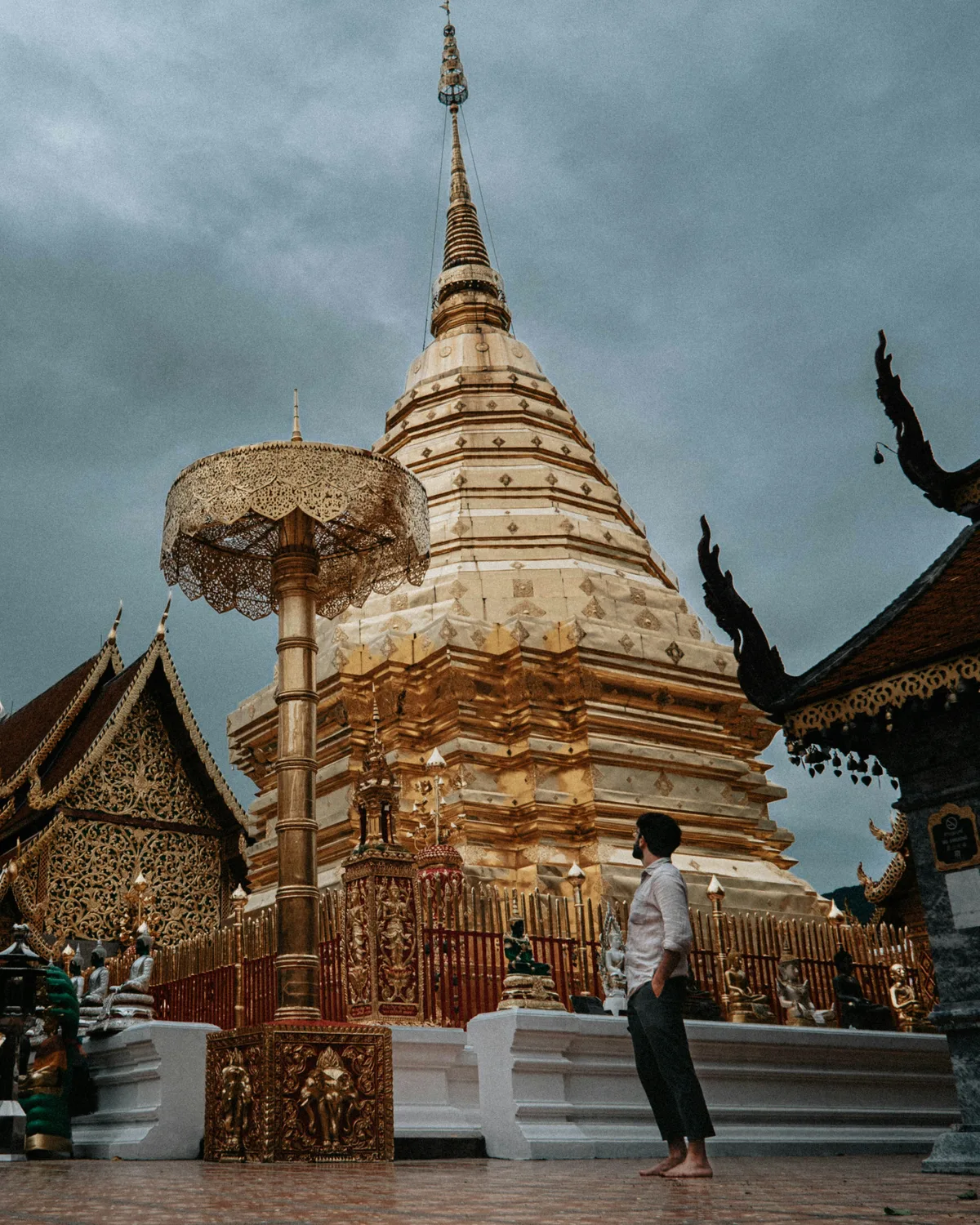 A man standing in front of the pagoda of Doi Suthep